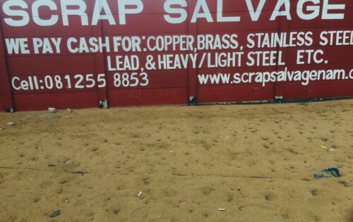 A large red wall with "SCRAP SALVAGE" written in prominent white letters.